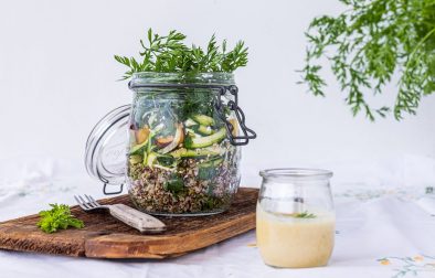 Gesunder Salat im Glas mit Quinoa, Gurken Nudeln und Pfirsich